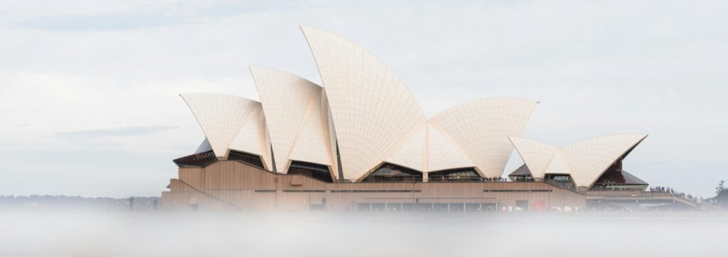 A foggy view of the iconic Sydney Opera House in Australia, capturing its distinctive sail-like architecture.