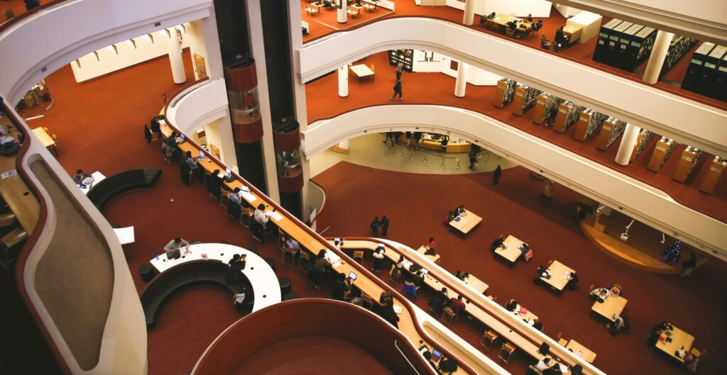 Aerial view of a multistory library interior with people studying at tables in Toronto.